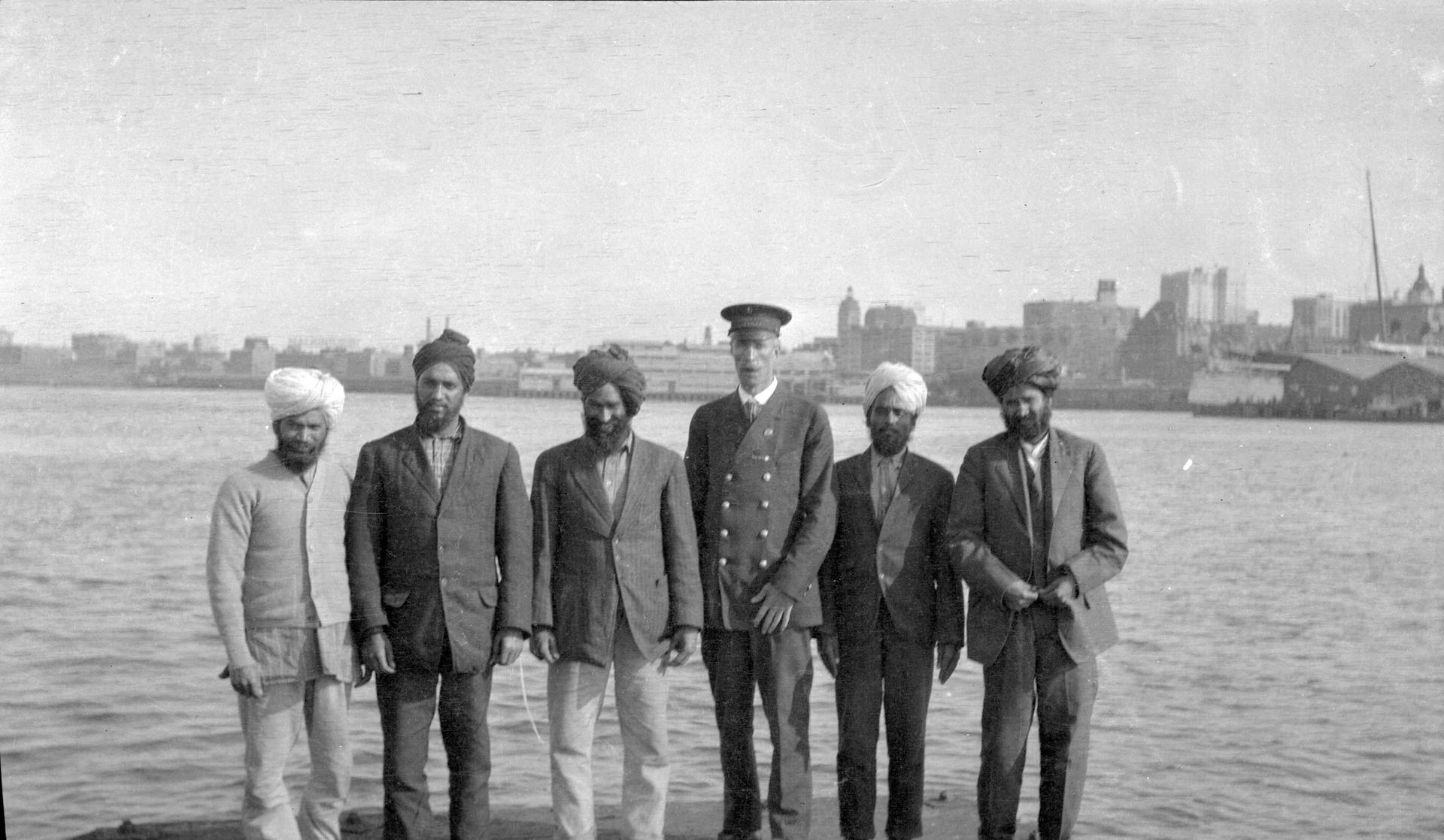 Passengers aboard the Komagata Maru in Vancouver harbor, with photographer James L.Quiney (in uniform)