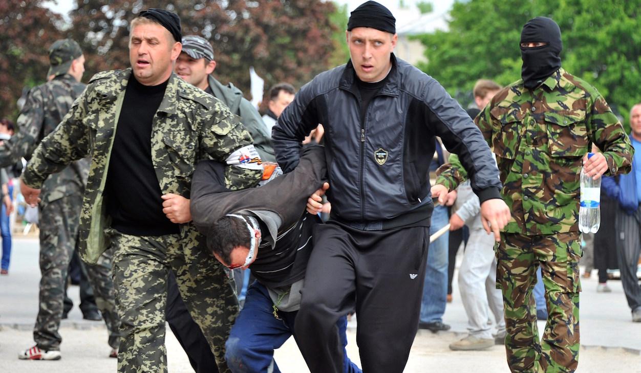 Ukraine pro-Russian rebels carry prisoner in Donetsk