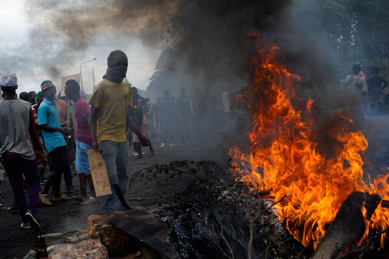 Protesters stand at a burning barricade in the Musaga neighborhood of Bujumbura, Burundi, on May 5, 2015.