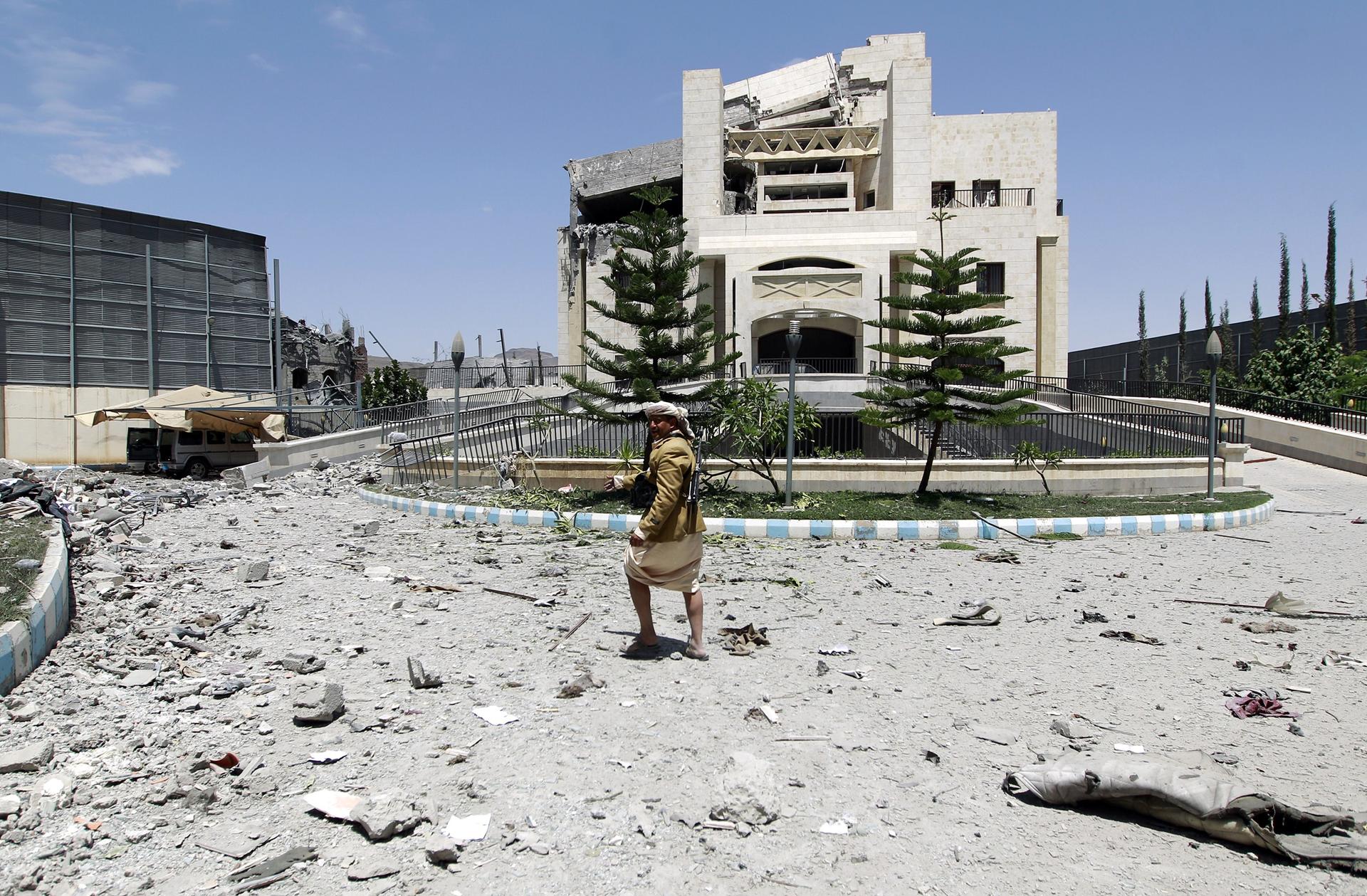 A gunman loyal to former Yemeni President Ali Abdullah Saleh stands amid the wreckage of Saleh's residence following airstrikes on May 10, 2015 in Sanaa.
