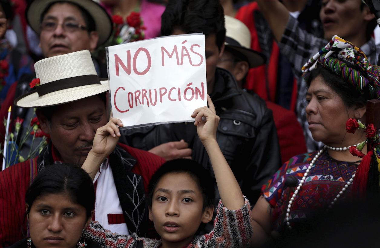 A boy holds a sign that says "no more corruption" during a demonstration demanding the resignation of Guatemalan President Otto Perez Molina on May 30, 2015. 