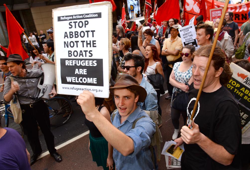 Protesters carry signs welcoming refugees to Australia during a rally in Sydney on Sept. 29, 2013.