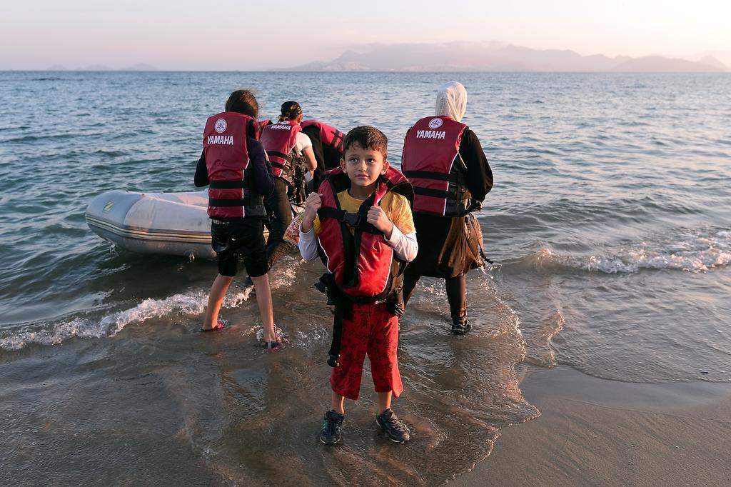 A group of migrants arrive on a beach on the Greek island of Kos on Aug. 18, 2015. 