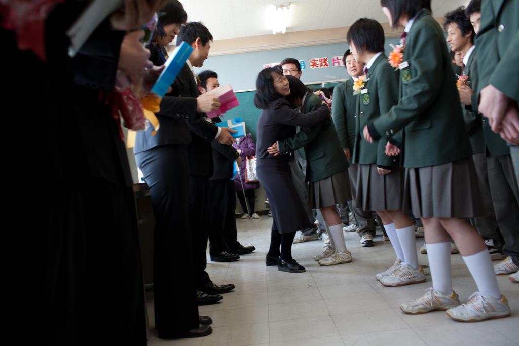 A teacher hugs a student during a graduation ceremony at the Rokugou junior school in Sendai, Miyagi Prefecture, on March 30, 2011.