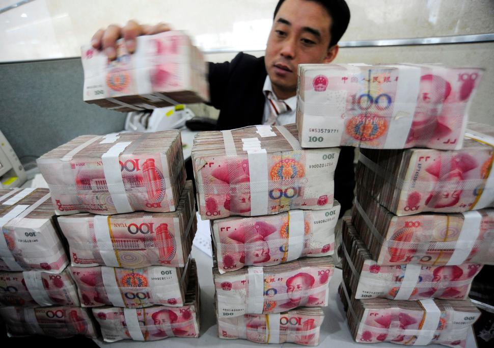 An employee counts renminbi banknotes at a Bank of China branch in Hefei, Anhui province, on Nov. 17, 2009.