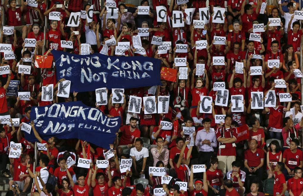 Hong Kong fans hold banners and character signs which read 'Hong Kong is not China,' during the Chinese national anthem at the 2018 World Cup qualifying match between Hong Kong and China in Hong Kong on Nov. 17, 2015.