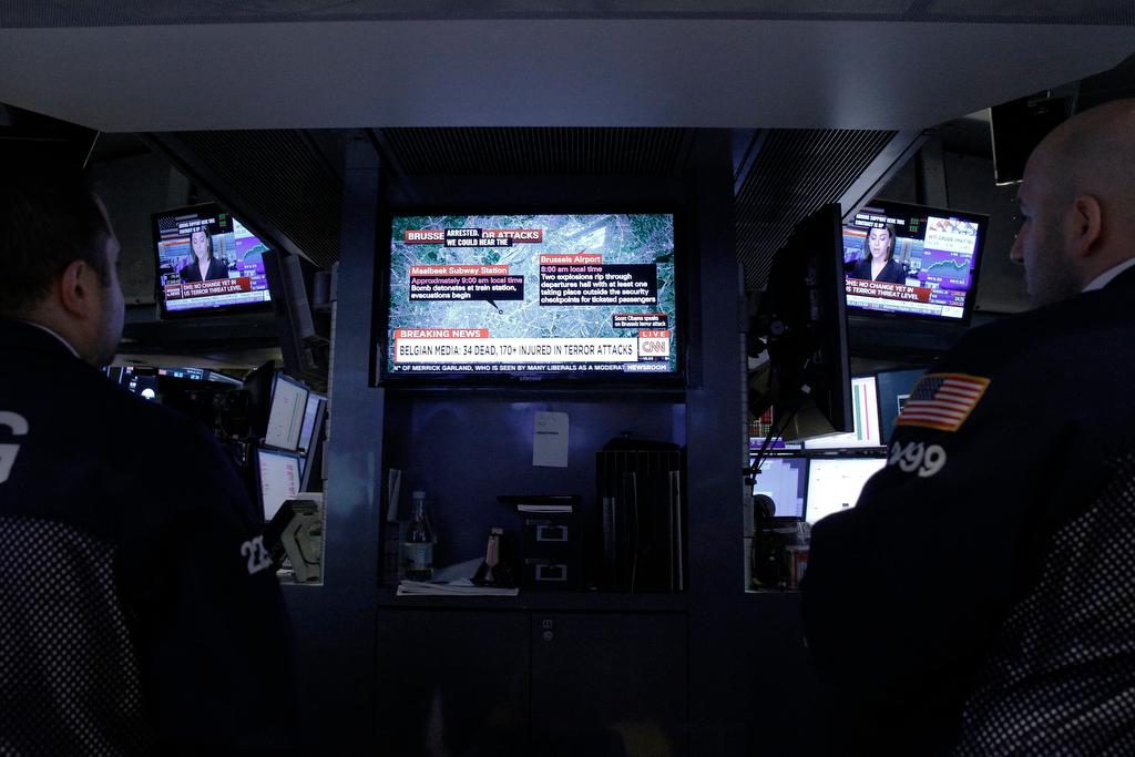 Traders watch developments following the explosions in Brussels on the floor of the New York Stock Exchange on March 22, 2016.