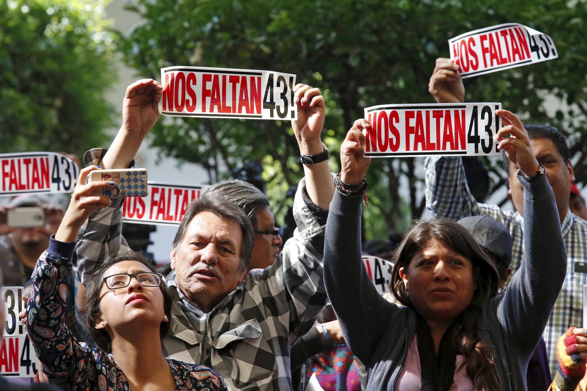Activists hold signs that read "We are missing 43" during the delivery of the final report of the 43 missing students from the Ayotzinapa teacher's training college by members of the Inter-American Commission on Human Rights at Claustro de Sor Juana Unive