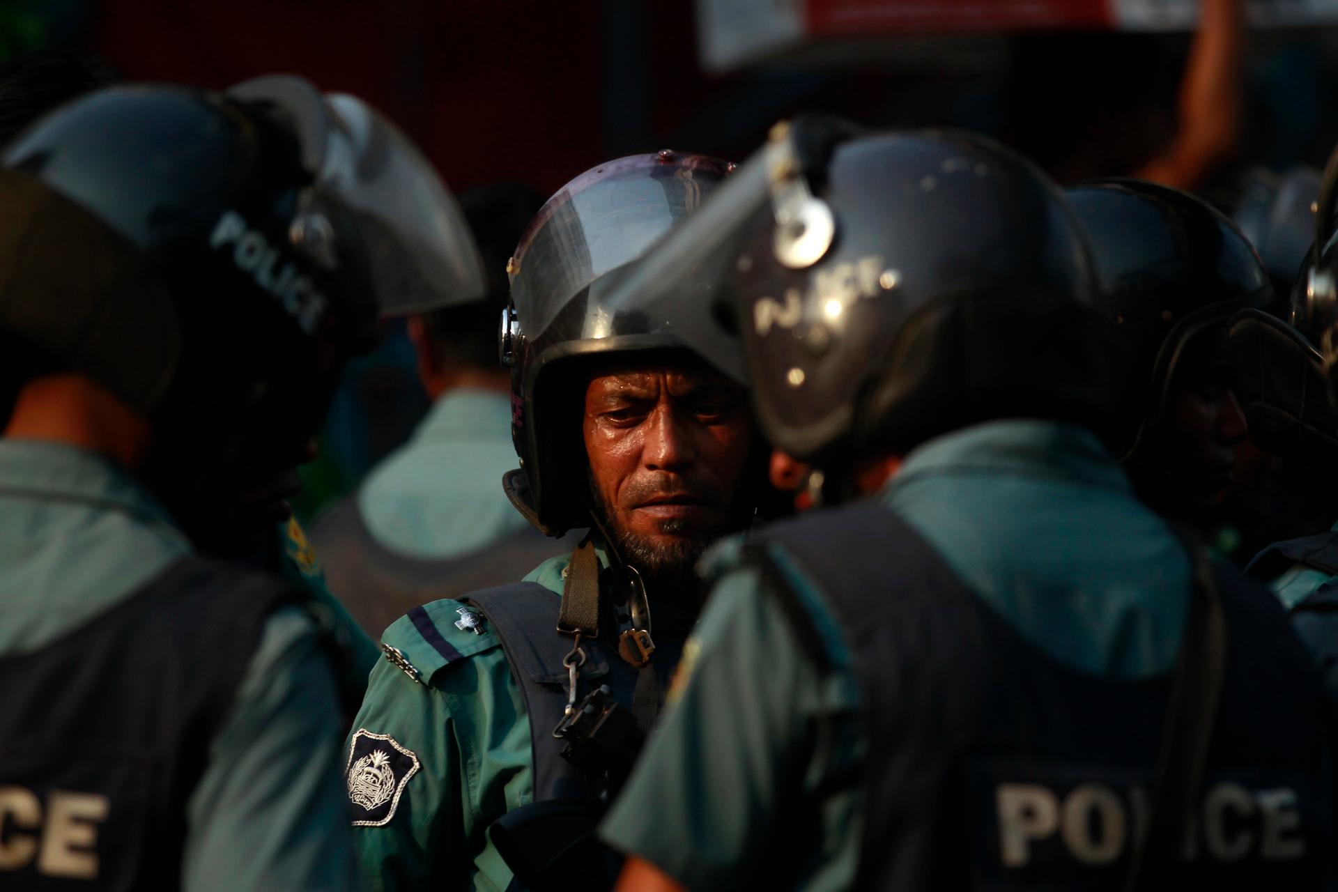 Police stand guard during a rally by activists of Hefajat-e-Islam in front of the national mosque in Dhaka on April 12, 2013.