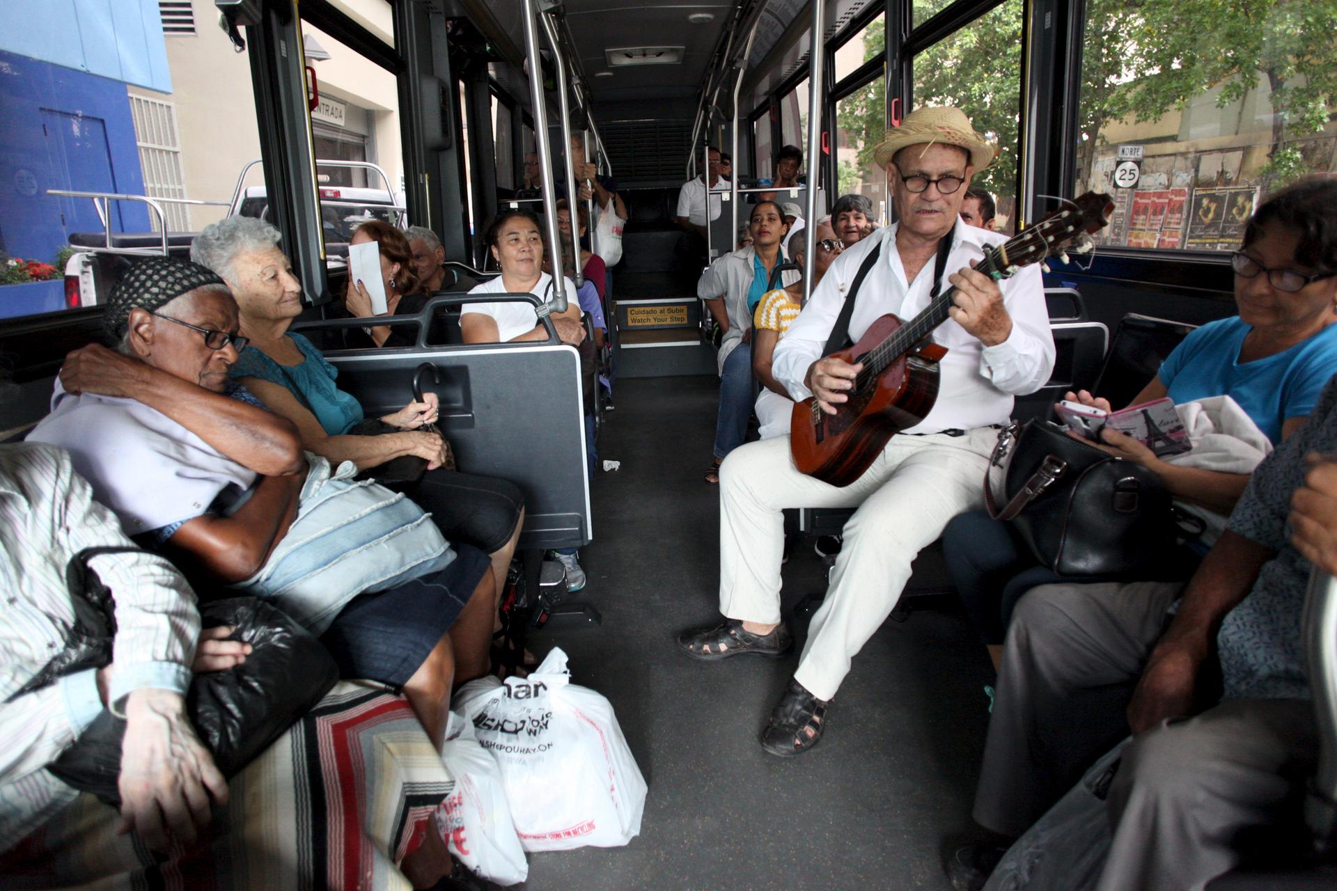Jorge Luis Jimenez plays the guitar for passengers on a public bus in San Juan, Puerto Rico, on Dec. 2, 2015