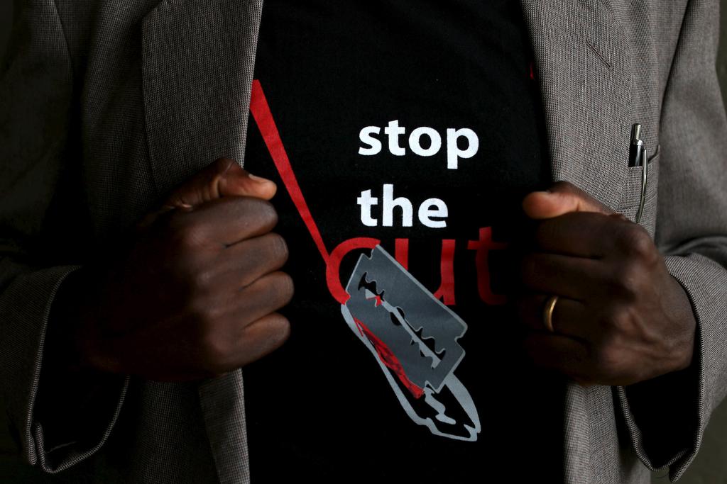 A man shows the logo of a T-shirt that reads "Stop the Cut" referring to Female Genital Mutilation (FGM) during a social event advocating against harmful practices such as FGM at the Imbirikani Girls High School in Imbirikani, Kenya, April 21, 2016.