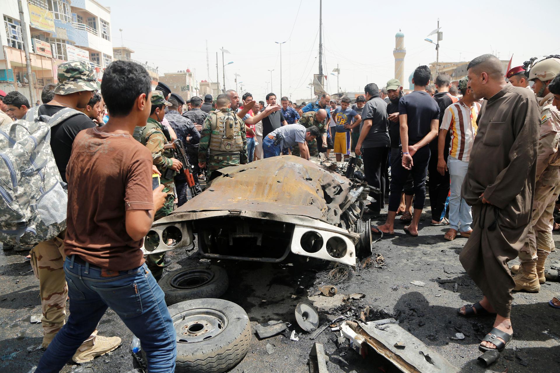 People gather at the scene of a car bomb attack in Baghdad's mainly Shi'ite district of Sadr City, Iraq, on May 11, 2016.