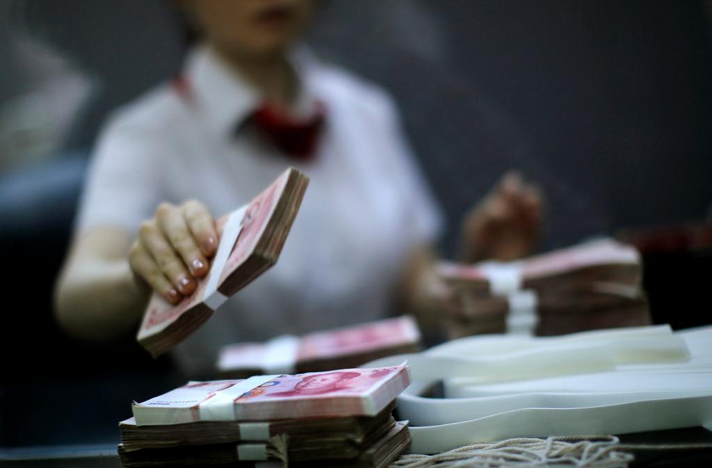 An employee of the Industrial and Commercial Bank of China Ltd (ICBC) counts money at one of the bank's branches at the Shanghai Free Trade Zone in Pudong district, in Shanghai September 24, 2014.