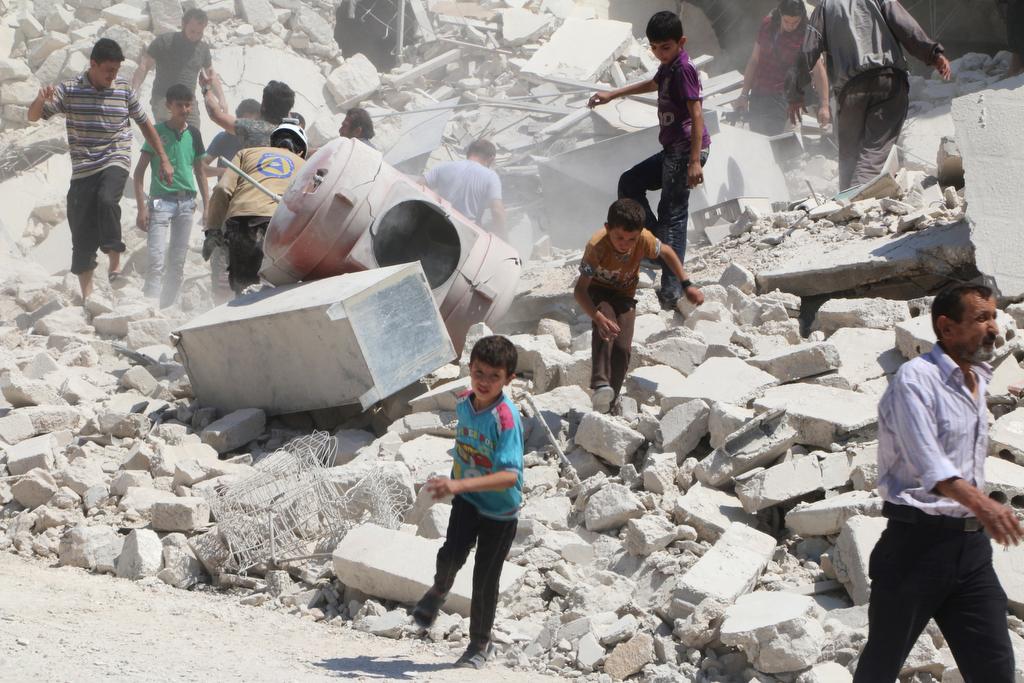 People walk on the rubble of a site hit by an airstrike in the rebel held area of Aleppo's al-Marjeh neighborhood, Syria June 6, 2016.