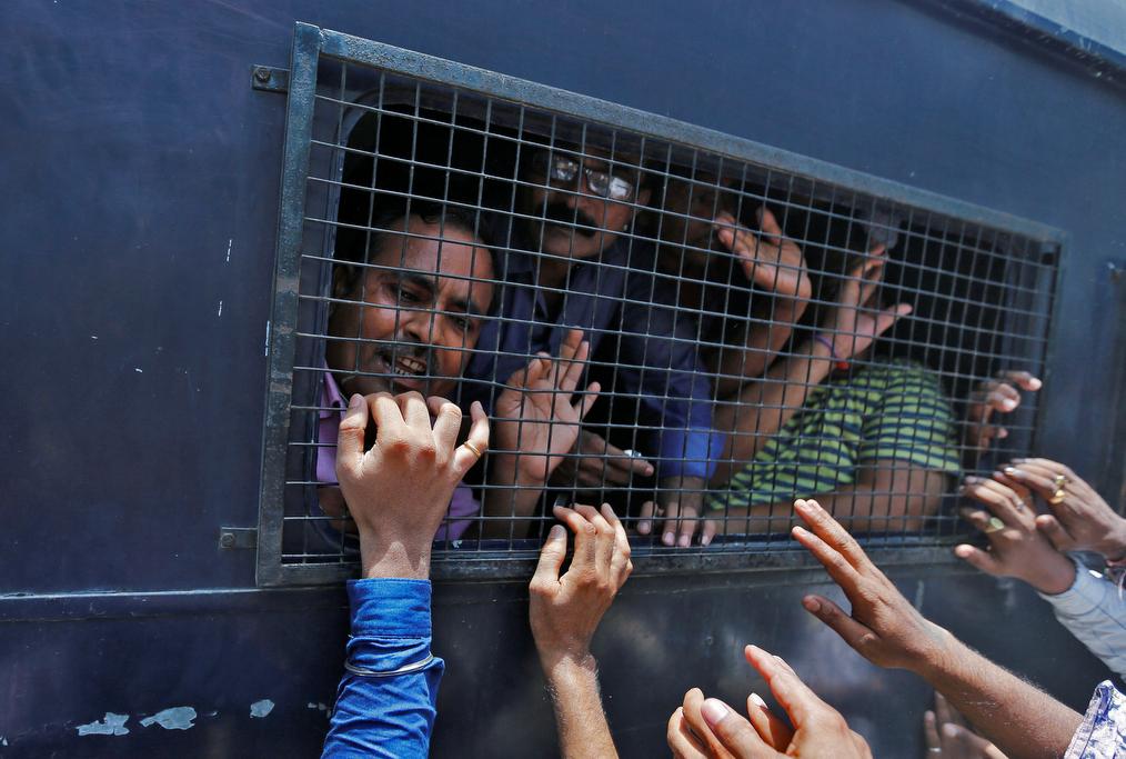 Some of those convicted in connection with a riot in Gujarat in 2002, look out from a police van outside a court after the ruling in Ahmedabad, India June 2, 2016.