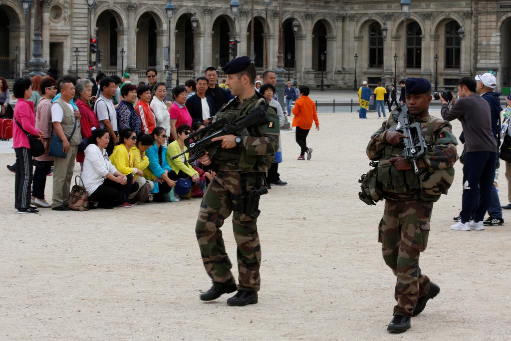 Chinese tourists take group pictures as French army soldiers patrol near the Louvre Museum Pyramid's main entrance in Paris, France, June 13, 2016 as the French capital is under high security during the UEFA 2016 European Championship. 