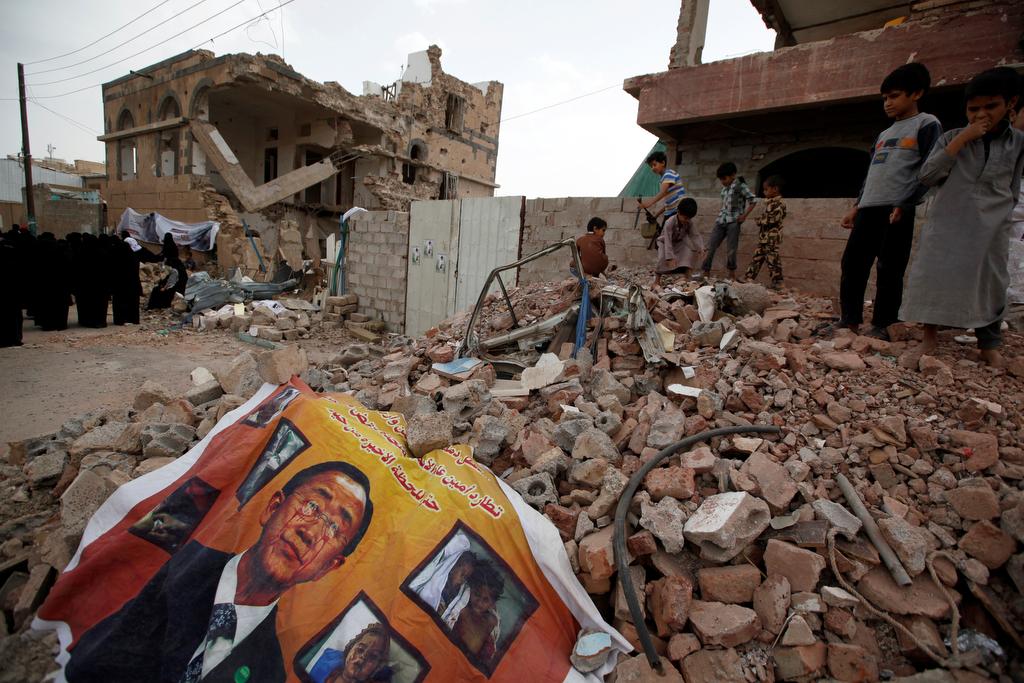A defaced poster of the U.N. Secretary-General Ban Ki-moon is seen on the rubble of a house during a vigil marking one year since a Saudi-led air strike on a residential area in Sanaa, Yemen June 21, 2016.