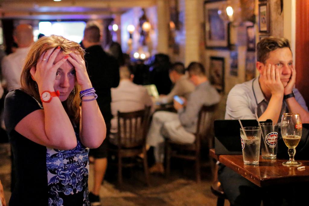 People gathered in The Churchill Tavern, a British themed bar in Manhattan, react as the BBC predicts Britain will leave the European Union.