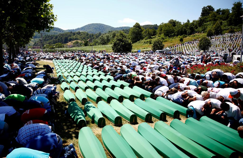 Muslim men pray in front of coffins during mass funeral in Potocari near Srebrenica, Bosnia and Herzegovina on July 11, 2016.