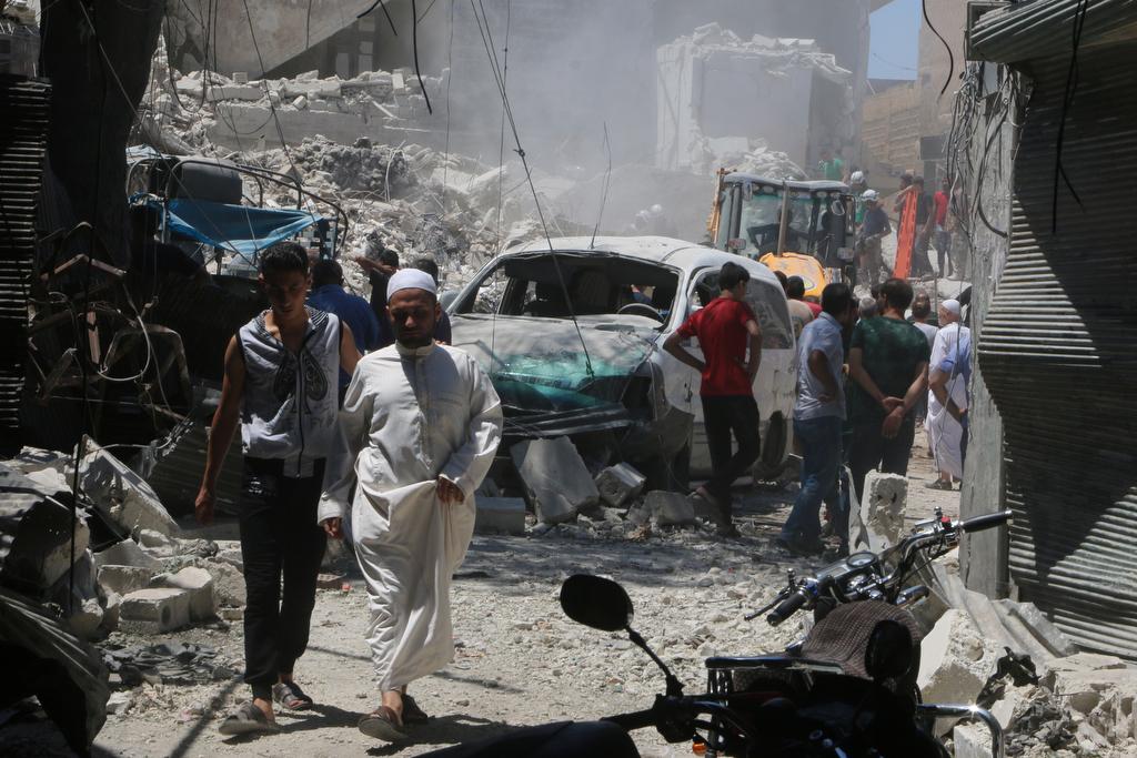 People inspect the damage at a site hit by a barrel bomb in the rebel held area of Old Aleppo, Syria July 11, 2016.