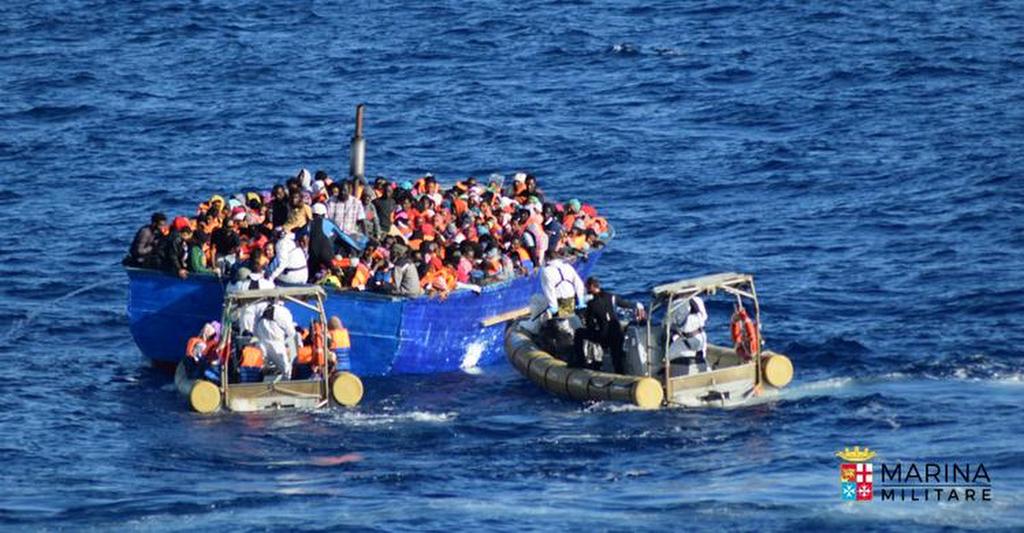 Migrants sit in their boat during a rescue operation by Italian navy ship Borsini (unseen) off the coast of Sicily, Italy, in this handout picture courtesy of the Italian Marina Militare released on July 19, 2016. 