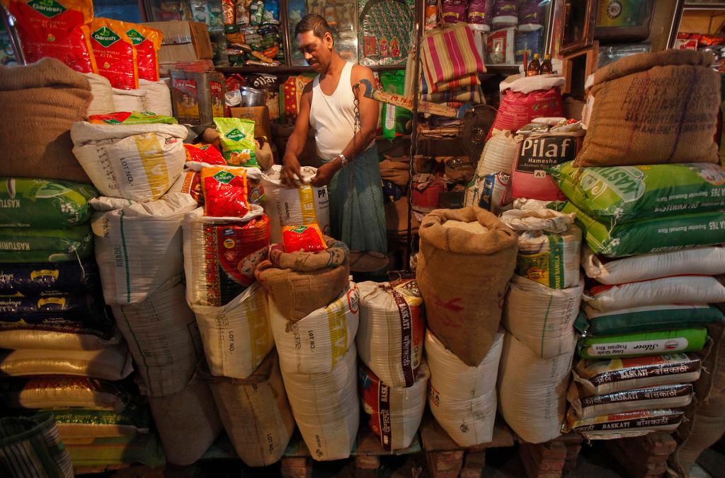The owner of a "Kirana," or mom-and-pop grocery store, arranges a rice sack in Kolkata on Oct. 24, 2013.