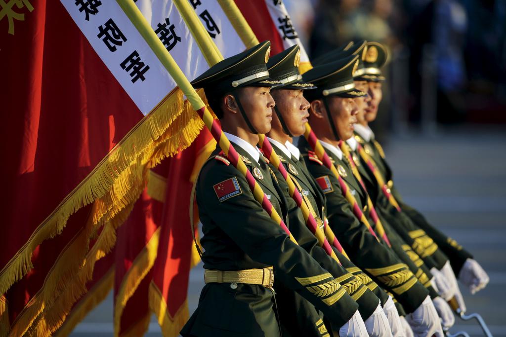 Paramilitary policemen carrying flags prepare in front of the Tiananmen Gate ahead of the military parade to mark the 70th anniversary of the end of World War Two, in Beijing, China, September 3, 2015.