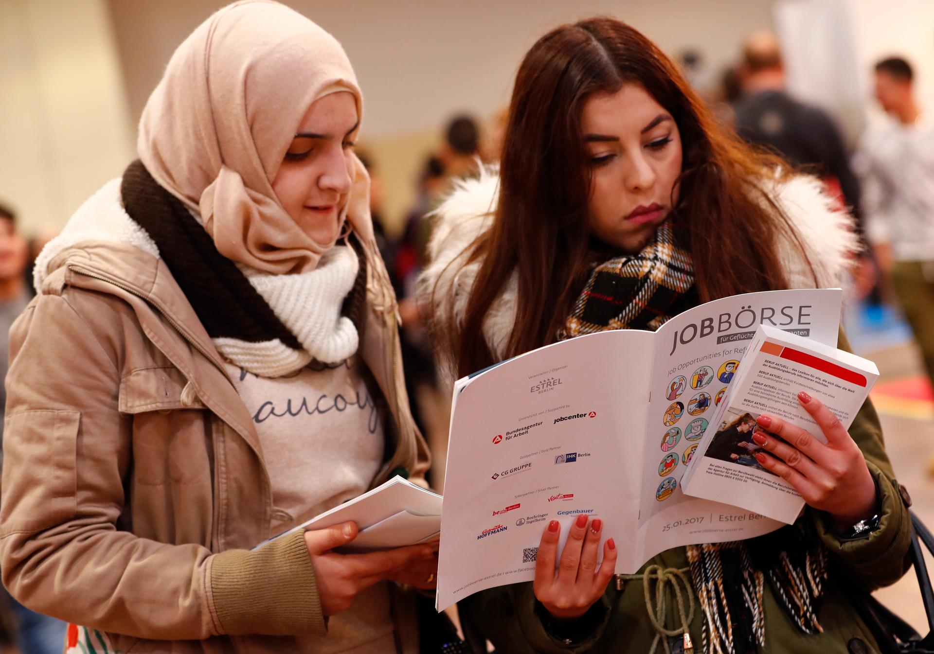 Two women visit a job fair for migrants and refugees in Berlin, Germany, Jan. 25, 2017.