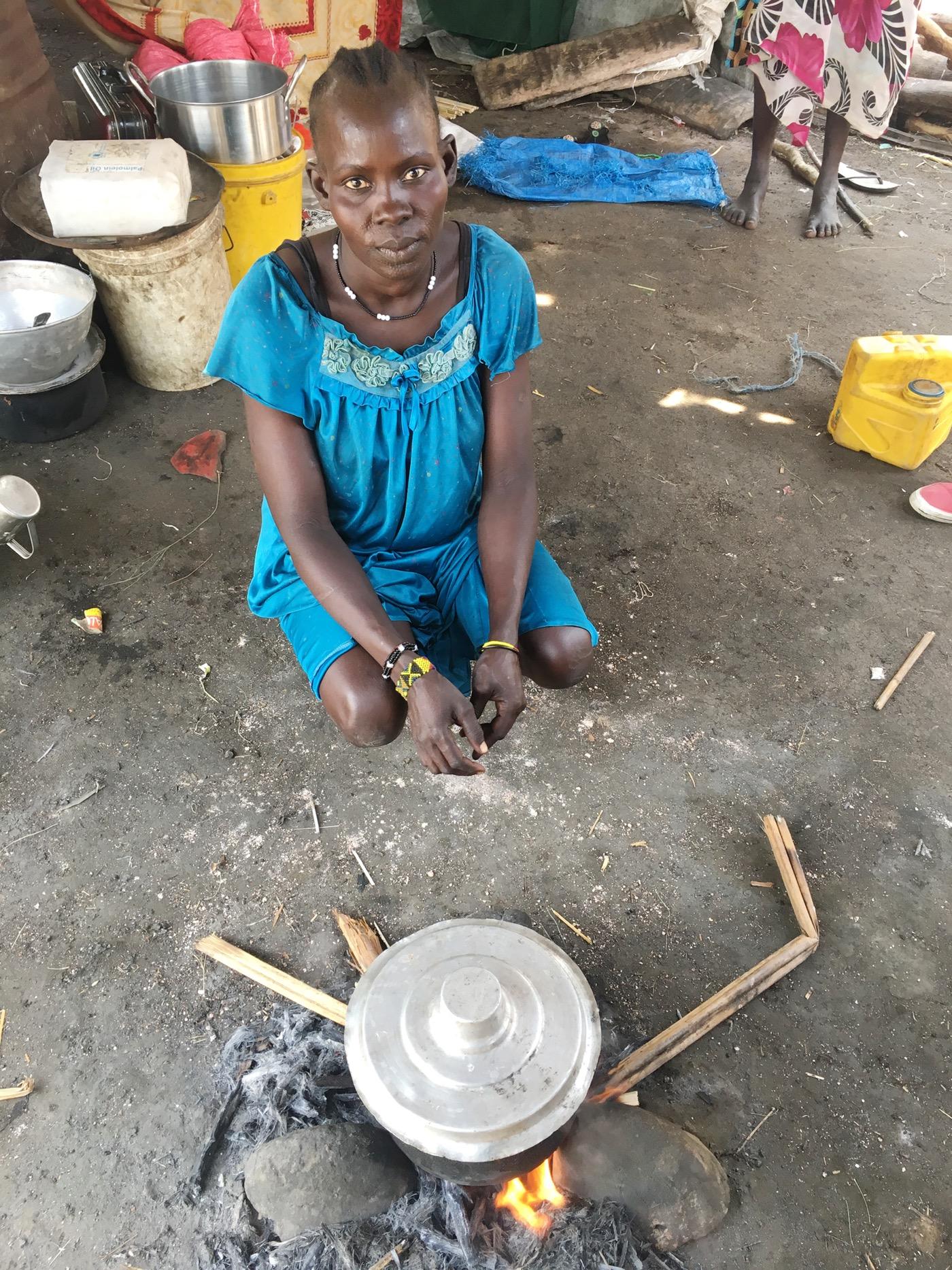 Veronica sits over a pot of boiling water, doing what she can to protect herself and her children from contracting cholera again.