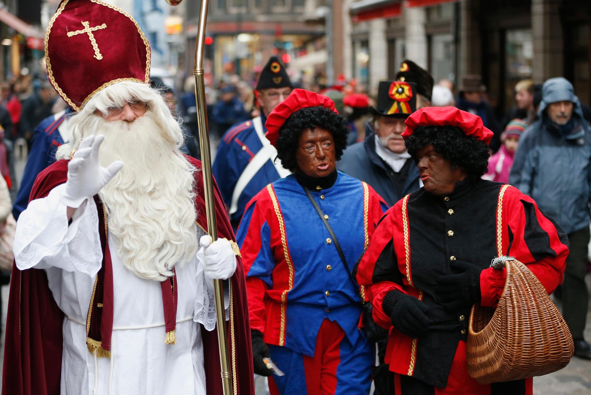 Saint Nicholas is followed by his two assistants called "Zwarte Piet" (Black Pete) during a traditional holiday parade.