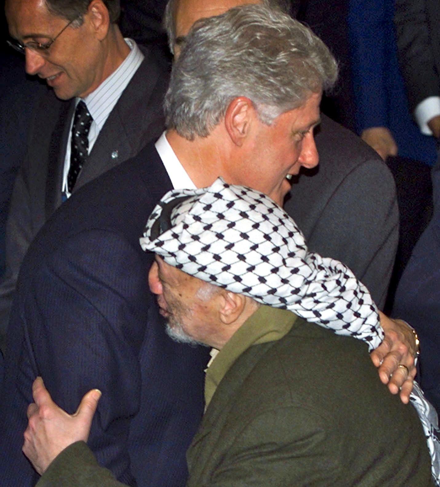 U.S. President Bill Clinton hugs with PLO Chairman Yasser Arafat in Davos, Switzerland, January 29, 2000.
