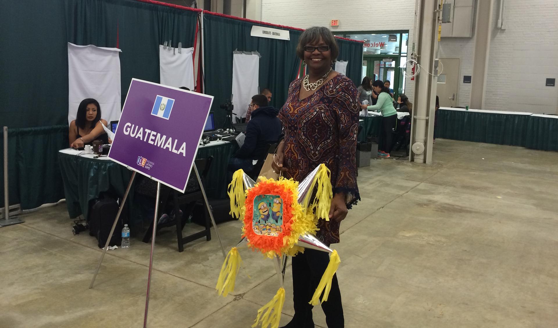 A woman stands in conference area in front of "Guatemala" sign