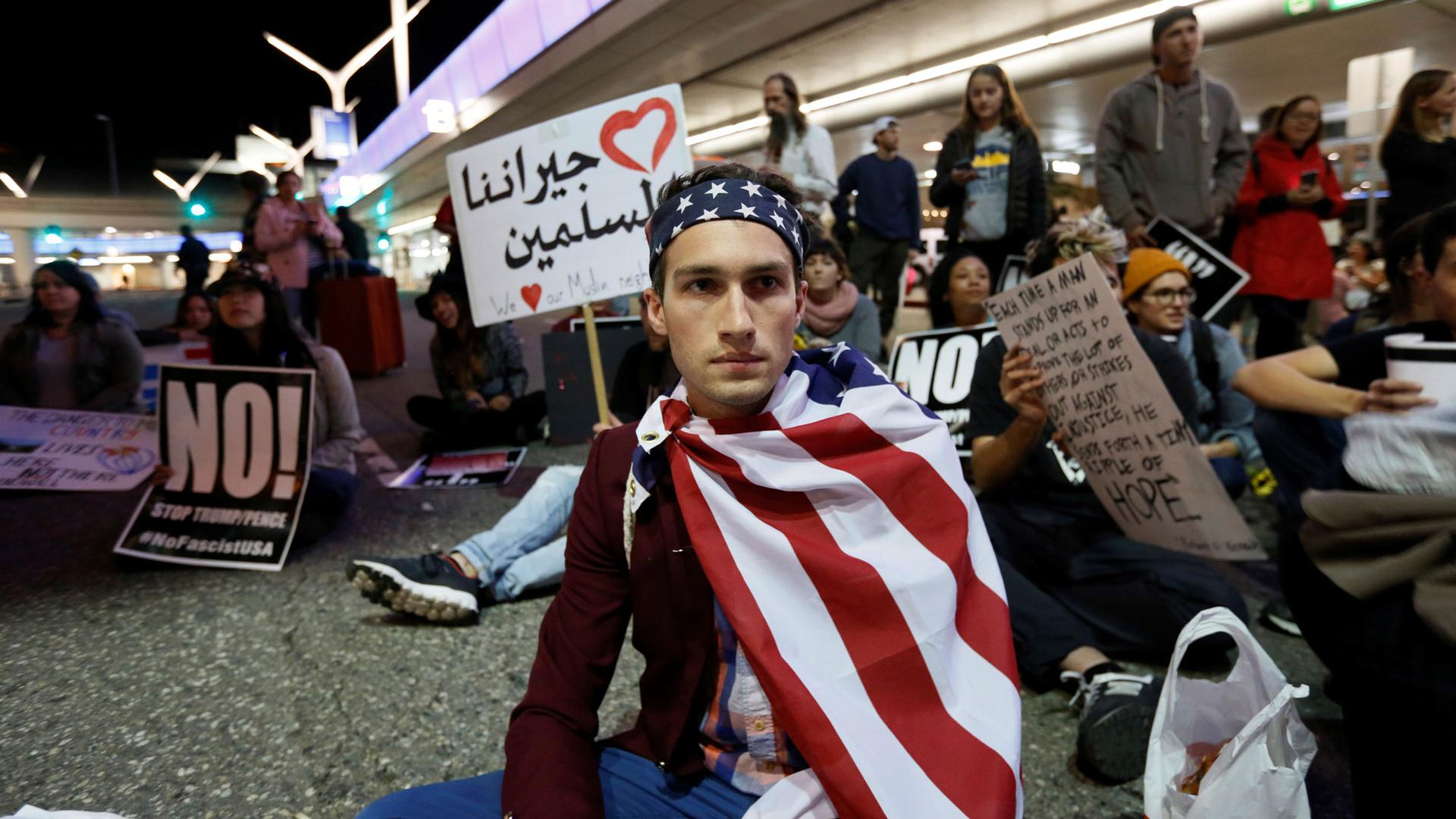 Demonstrators shut down the traffic loops at LAX International Airport and yell slogans during a protest against the travel ban imposed by President Donald Trump's executive order.