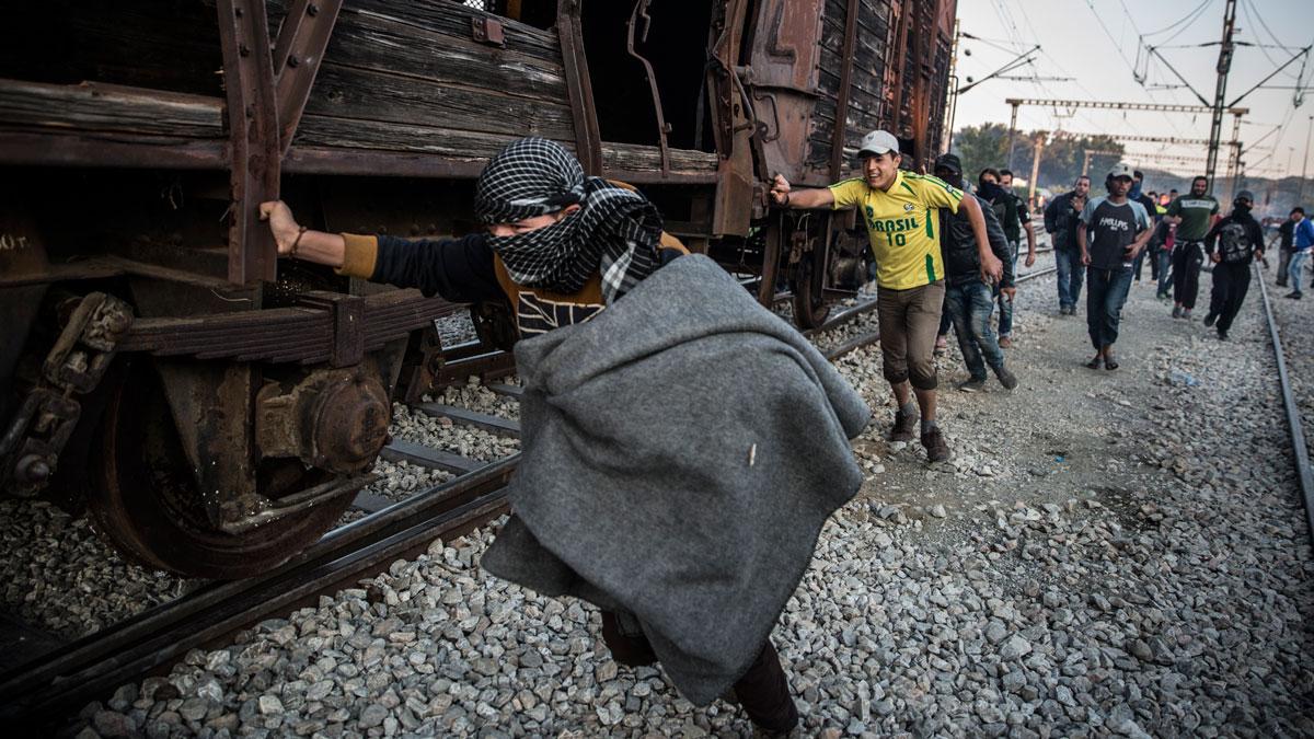 Protesting migrants pushed an abandoned train wagon toward the border during a protest on May 18, 2016, at Idomeni camp. Clashes ensued between Greek police, who fired tear gas and stun grenades and immigrants.