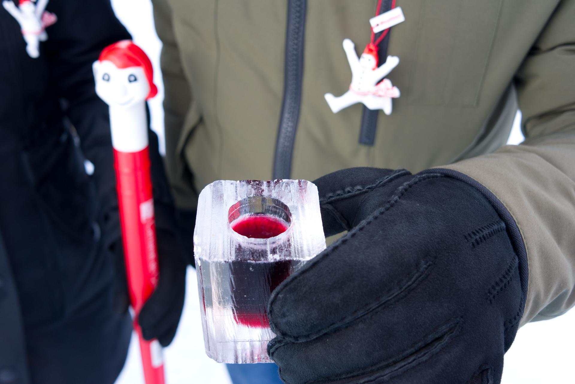 A Quebec City carnival-goer warms up with a cold one – Caribou on ice.  Quebec consumes up to 5,000 cases of Caribou yearly, nearly all of it during the winter carnival, and most of that outdoors.