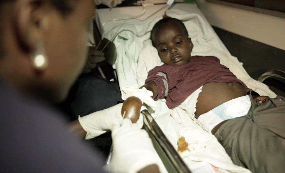 Natasha, a paramedic in Haiti's first-ever ambulance serivce, gives cholera patient an IV drip in her ambulance.