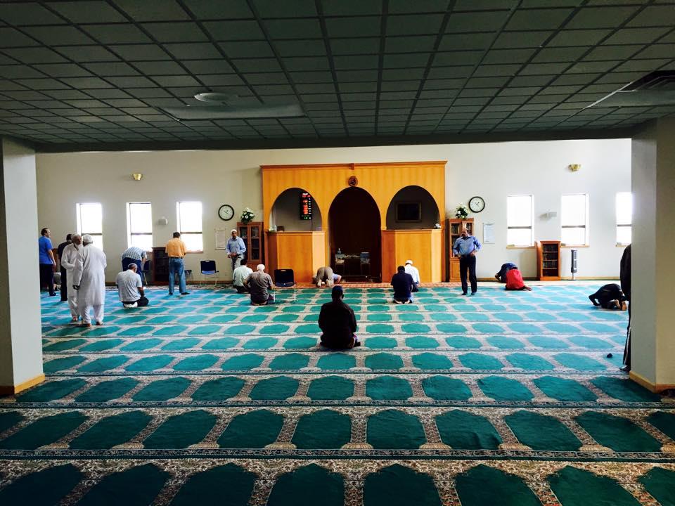 A few men pray in an open room