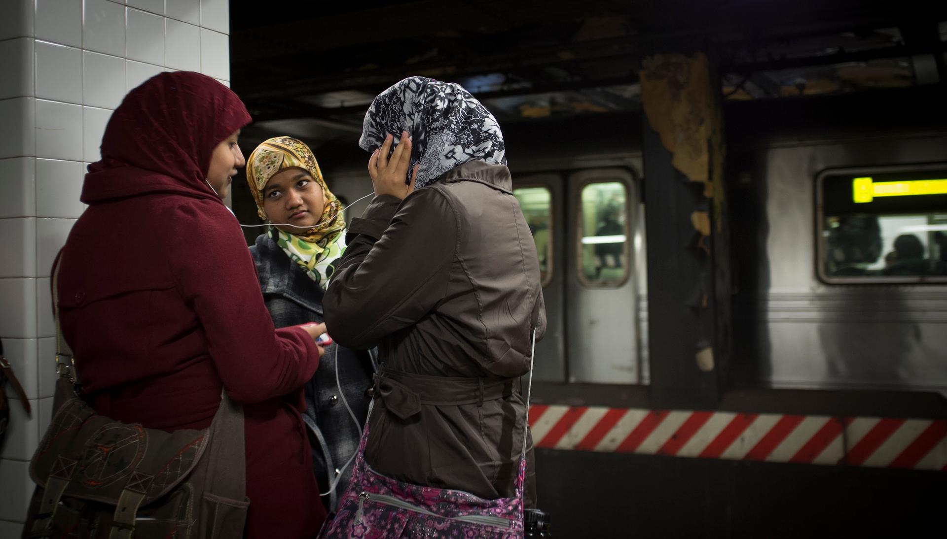 Three women wearing hijab, the headscarf worn by some Muslim women, on a platform in the New York City subway. Australians feared that Muslims on public transportation would be harassed following the Sydney hostage crisis.