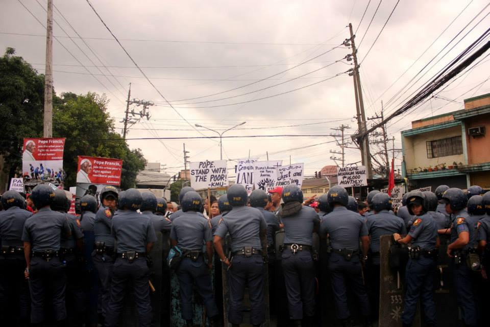 Phillipine police block protesters from marching within sight of Pope Francis' motorcade in Manila on January 15, 2015.