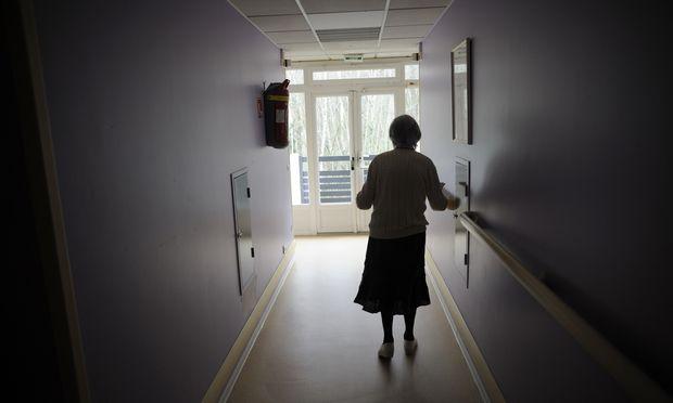 A woman, suffering from Alzheimer's desease, walks in a corridor on March 18, 2011 in a retirement house.