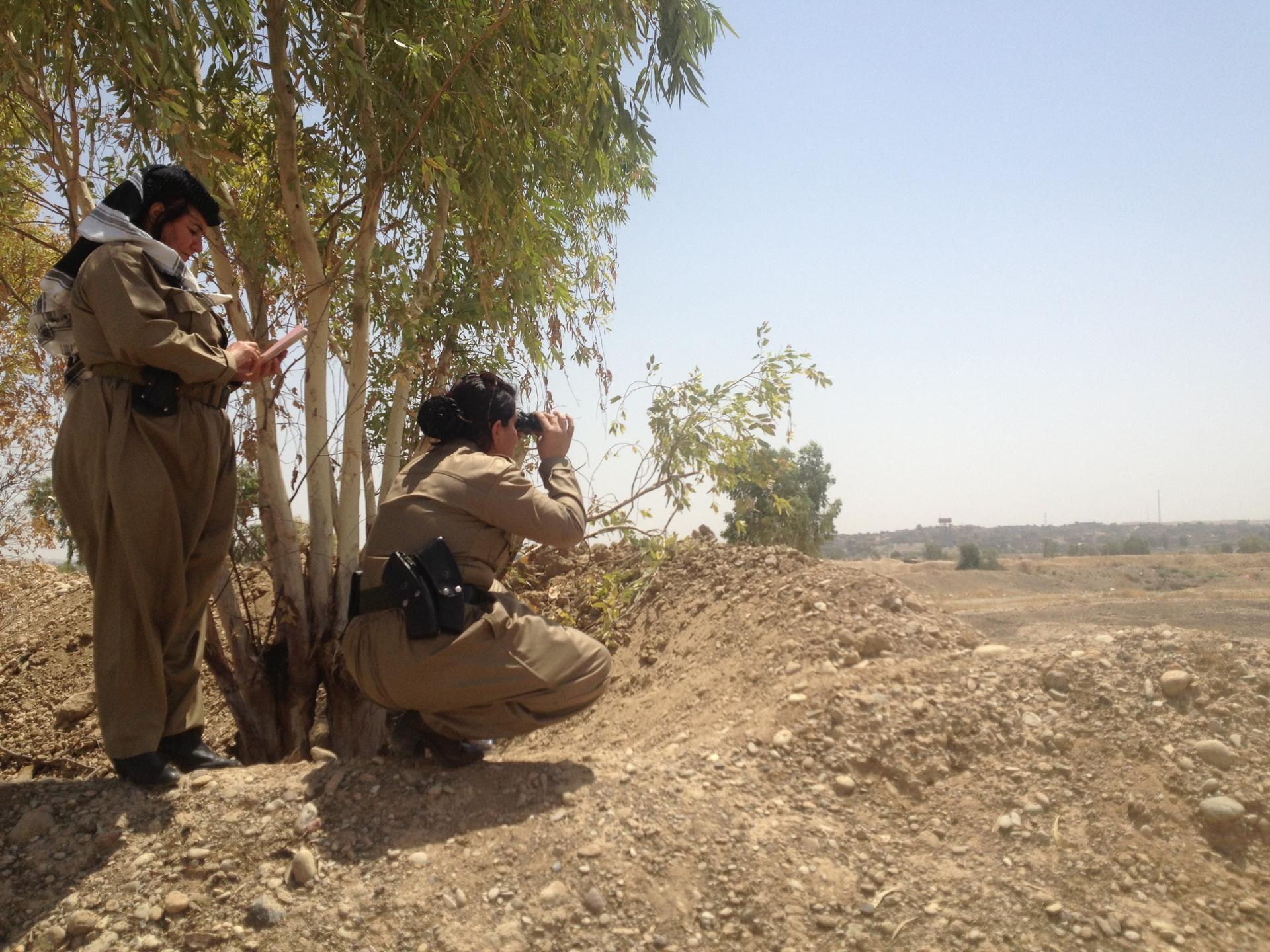Female fighters from Colonel Nahida's peshmerga battalion view the front lines with ISIS.