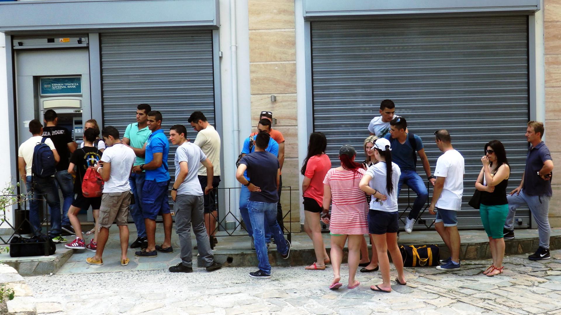 People lined up outside of an ATM in Greece.
