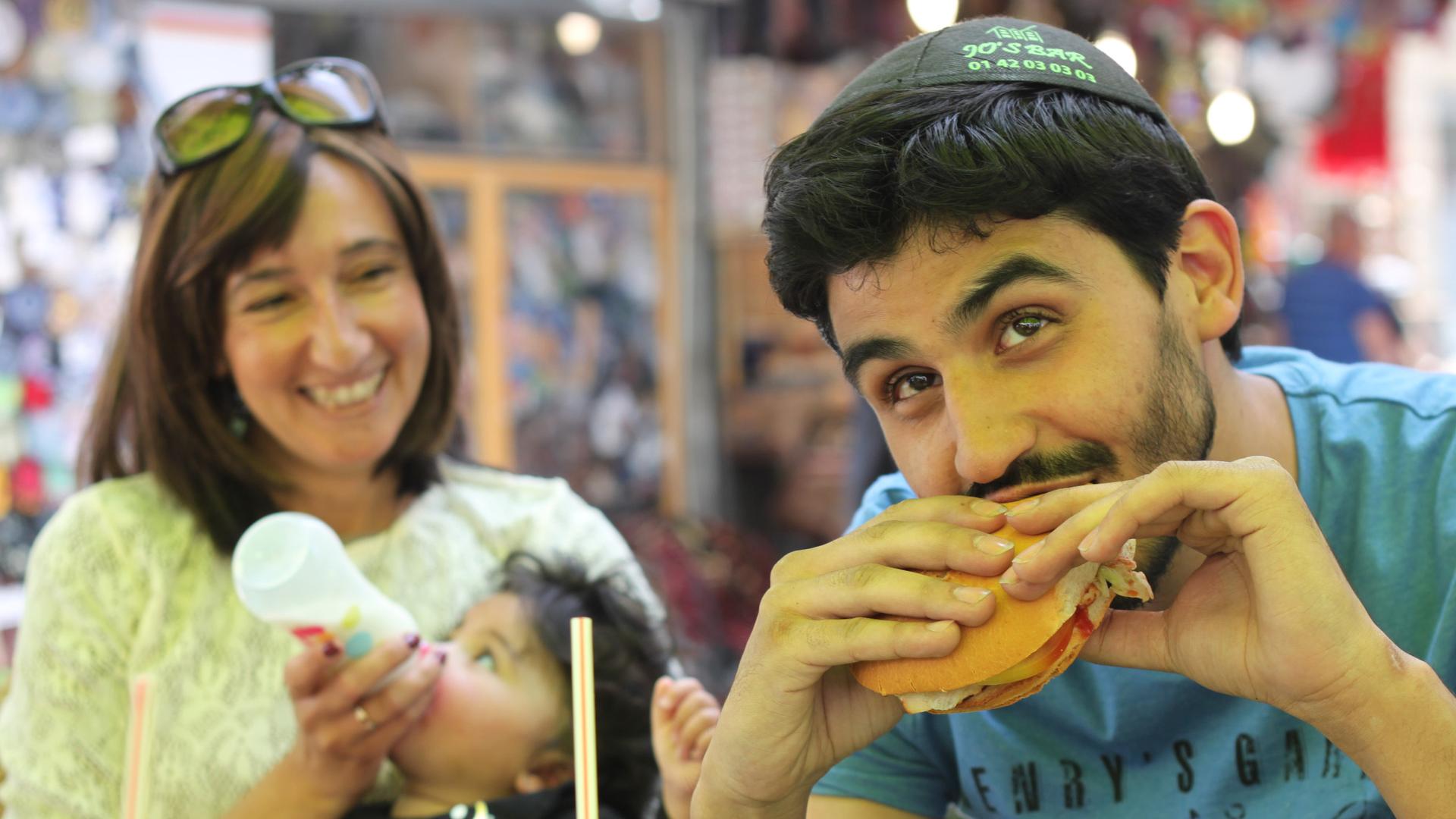 A French tourist eats a kosher McDonalds hamburger with a potato-starch bun in downtown Jerusalem.