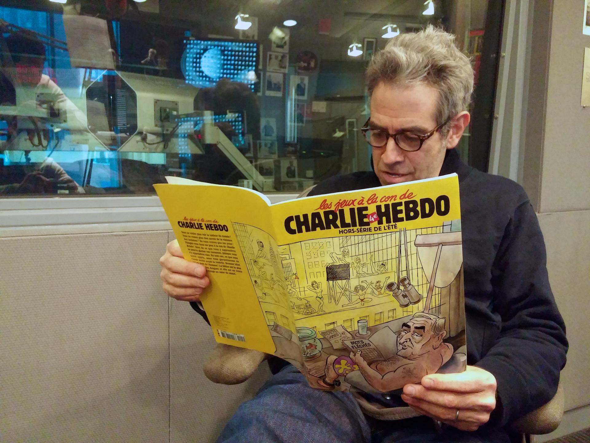 Marco Werman reads an issue of French satirical newspaper Charlie Hebdo he bought during a trip to France in 2011.