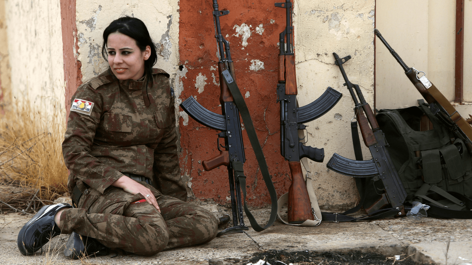 A Yazidi woman who joined the Kurdish Peshmerga forces sits next to rifles in the town of Bashiqa, after it was recaptured from the Islamic State, east of Mosul, Iraq Nov. 10, 2016.
