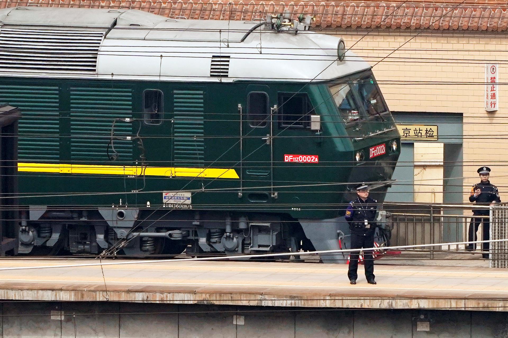 Police officers keep watch next to a train, believed to have carried a North Korean delegation to China