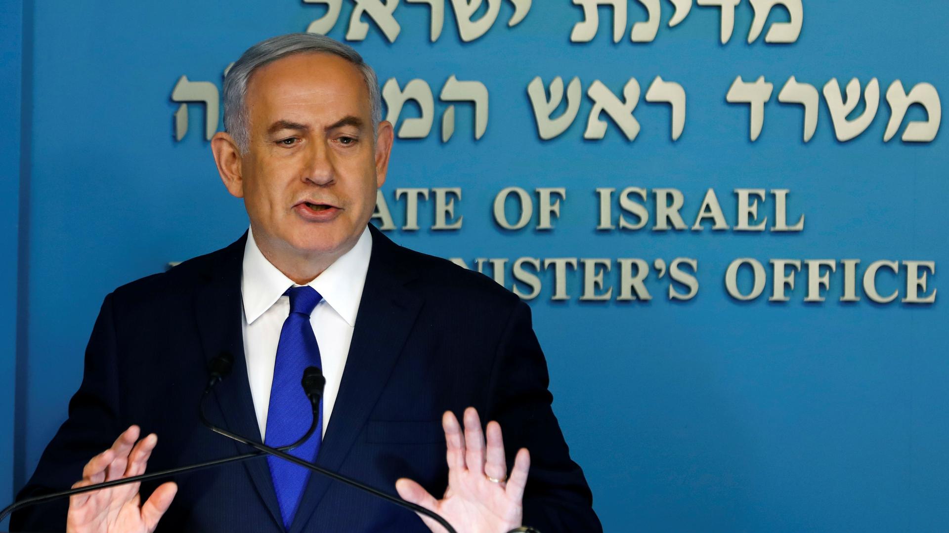 Israeli Prime Minister Benjamin Netanyahu speaks at a lectern before a blue background during a news conference at the Prime Minister's office in Jerusalem on April 2, 2018.