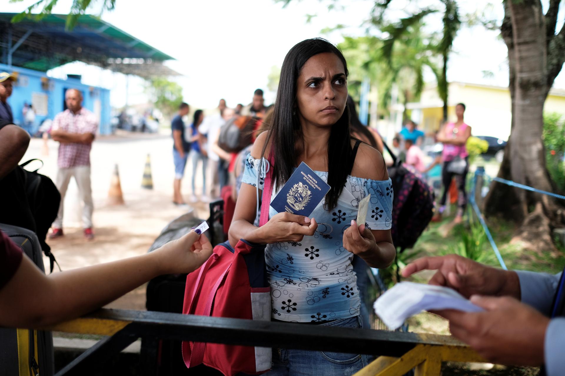 A Venezuelan woman shows her passport and identity card at the Pacaraima border control, Roraima state, Brazil, November 16, 2017. 