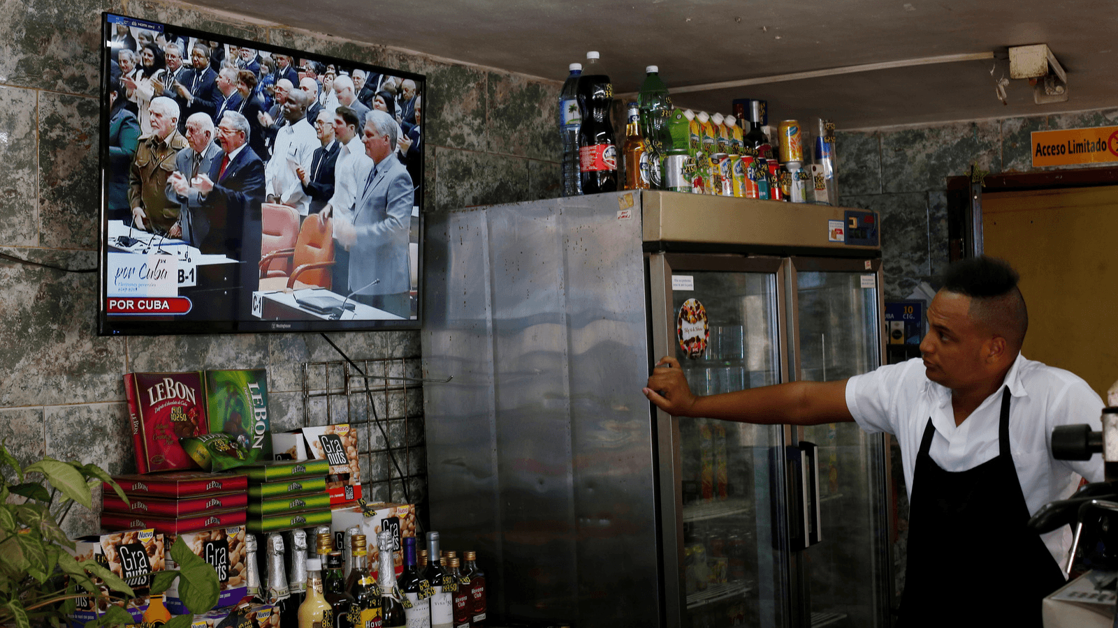 Cuba's President Raul Castro (C) and First Vice-President Miguel Díaz-Canel (R) are seen on a TV screen inside a restaurant during a session of the National Assembly in Havana, Cuba, April 18, 2018. Díaz-Canel became Cuba's president on Wednesday. 