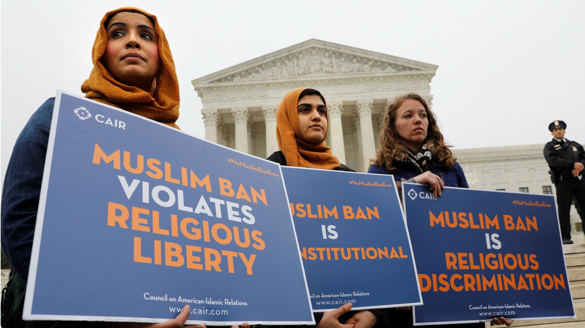 Protesters gather outside the U.S. Supreme Court in Washington, DC, U.S., April 25, 2018, while the court justices consider case regarding presidential powers as it weighs the legality of President Donald Trump's latest travel ban.